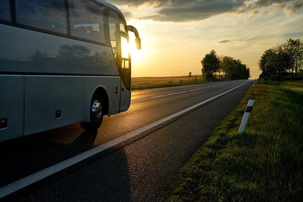 Auf dem Bild ist ein Reisebus auf einer Straße zu sehen.