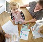 Familie Hopp am Tisch bei der Planung einer kontrollierten Wohnraumlüftung.