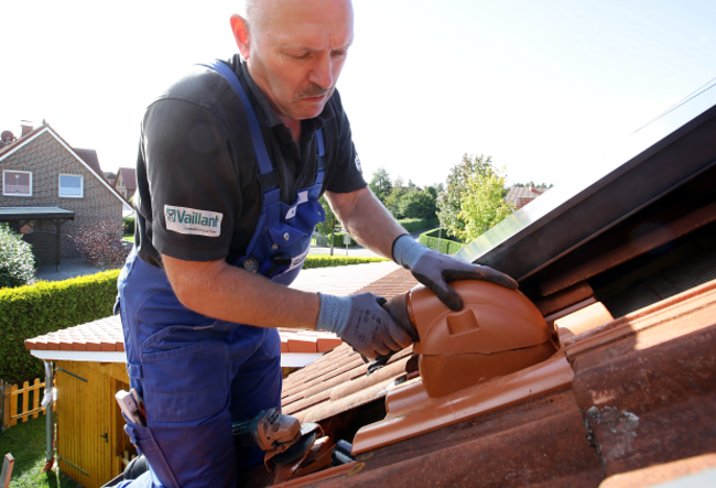 Handwerker verlegt Solar-Dachziegel.