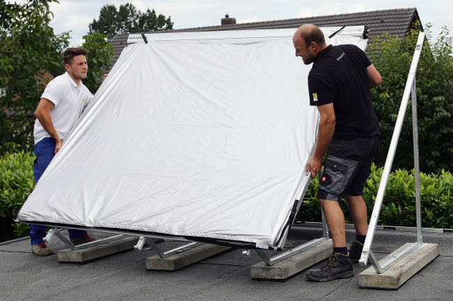 Handwerker stellen Kollektoren auf.