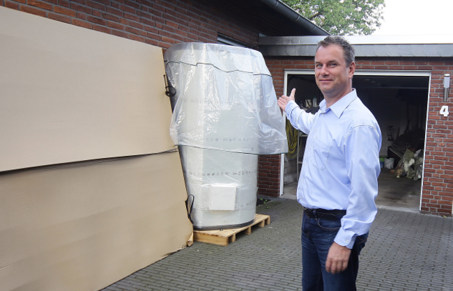 Carsten Mönkemeyer vor der verpackten Solarthermieanlage.