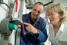 Handwerker erklärt Frau eine Pumpe