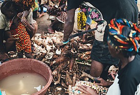 Afrikanische Frauen schälen Manjok